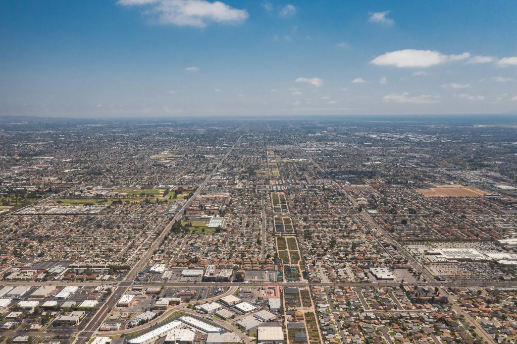 Expansive aerial view of Los Angeles urban landscape under a clear blue sky.